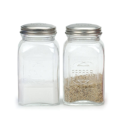 A glass salt and pepper shaker set filled partway with salt and pepper on a white background.