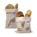 Two bread bags with printed designs filled with bread on a white background