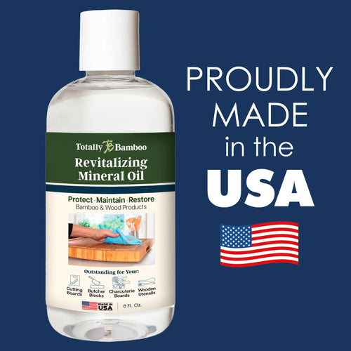 Bottle of Totally Bamboo Revitalizing Mineral Oil with label on a blue background, featuring the text 'Proudly Made in the USA' and an American flag.