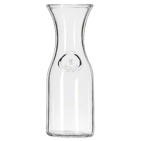 A clear glass wine decanter with a flared top and an emblem on the front. It has a convenient pour line and a grape design etched into the base.