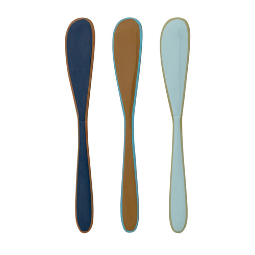 Three colorful canape knives on a white background
