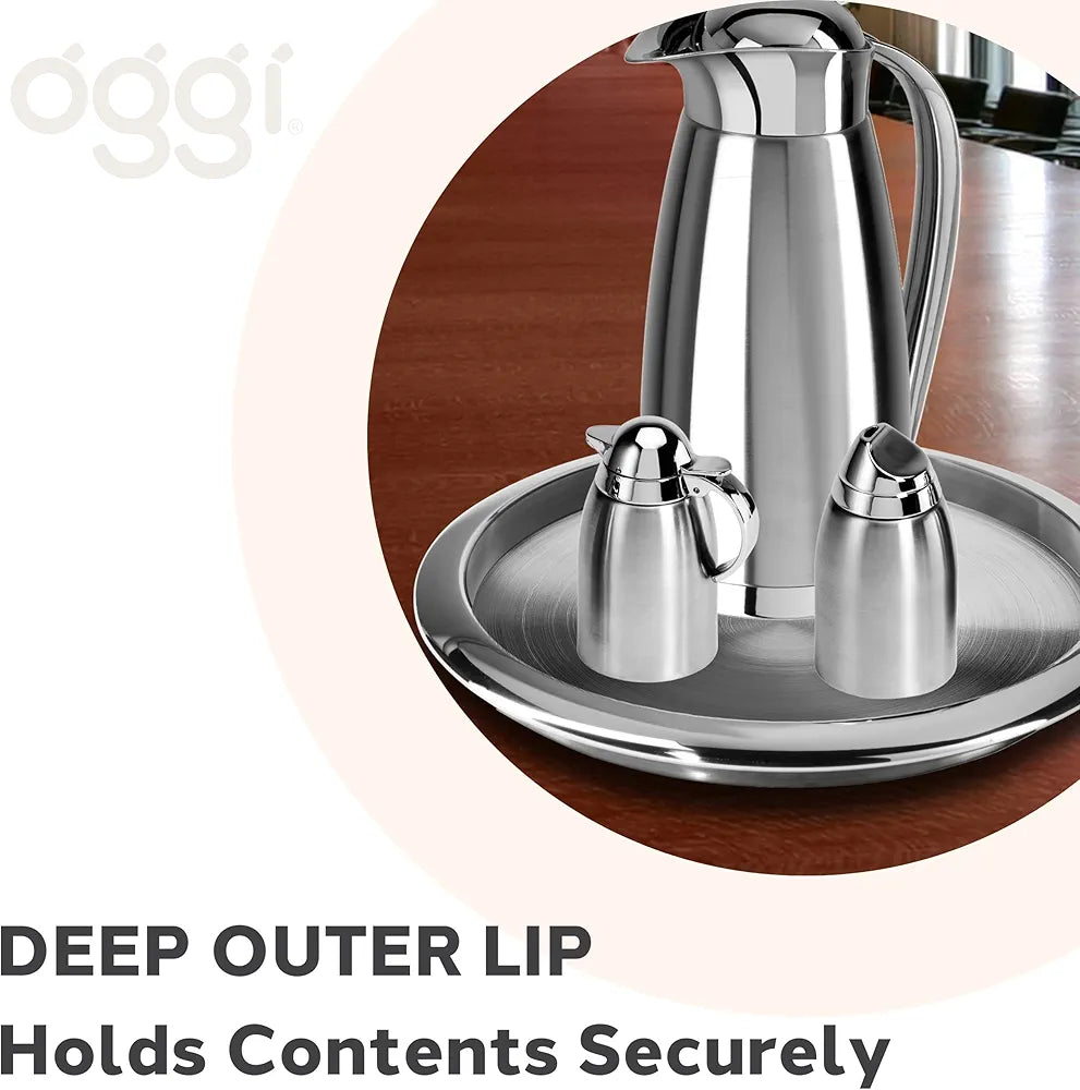 Silver coffee carafe set on a silver tray on a wooden surface with details about the tray in the corner.