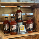 Four bottles of Rowdy Red displayed in a wooden crate with a card from King Bee.