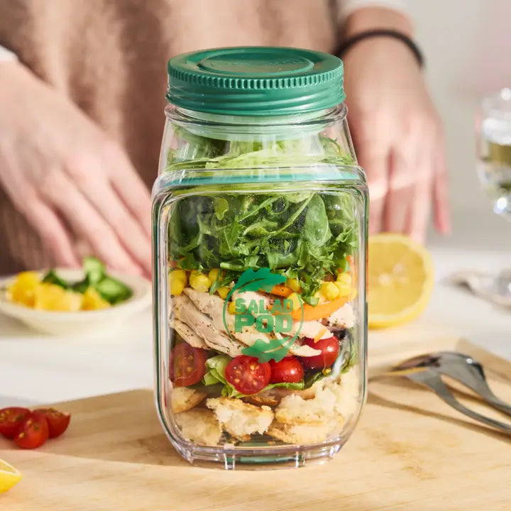 Mason jar salad with visible brand logo on a wooden table.