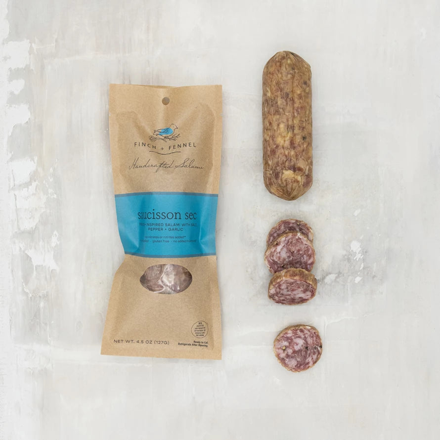 Finch & Fennel salami package with a sliced salami on a textured white background