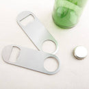 Two silver bottle openers next to a green bottle and a silver bottlecap on a white background.