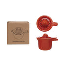 Red stoneware juicer set with packaging on a white background