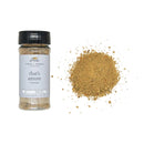 Jar of 'that's amore' topper with a pile of spices beside it on a white background.
