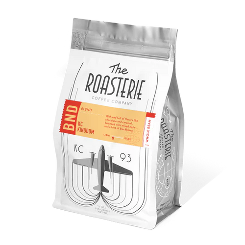 A bag of Roasterie coffee called KC Kingdom Blend with an airplane on a white background.