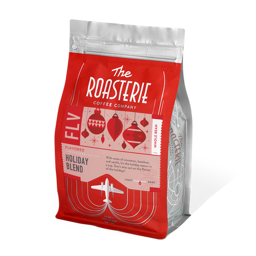 A pack of The Roasterie-Decaf Holiday Blend coffee, with red and white packaging, featuring holiday-themed graphics such as Christmas trees and a airplane.