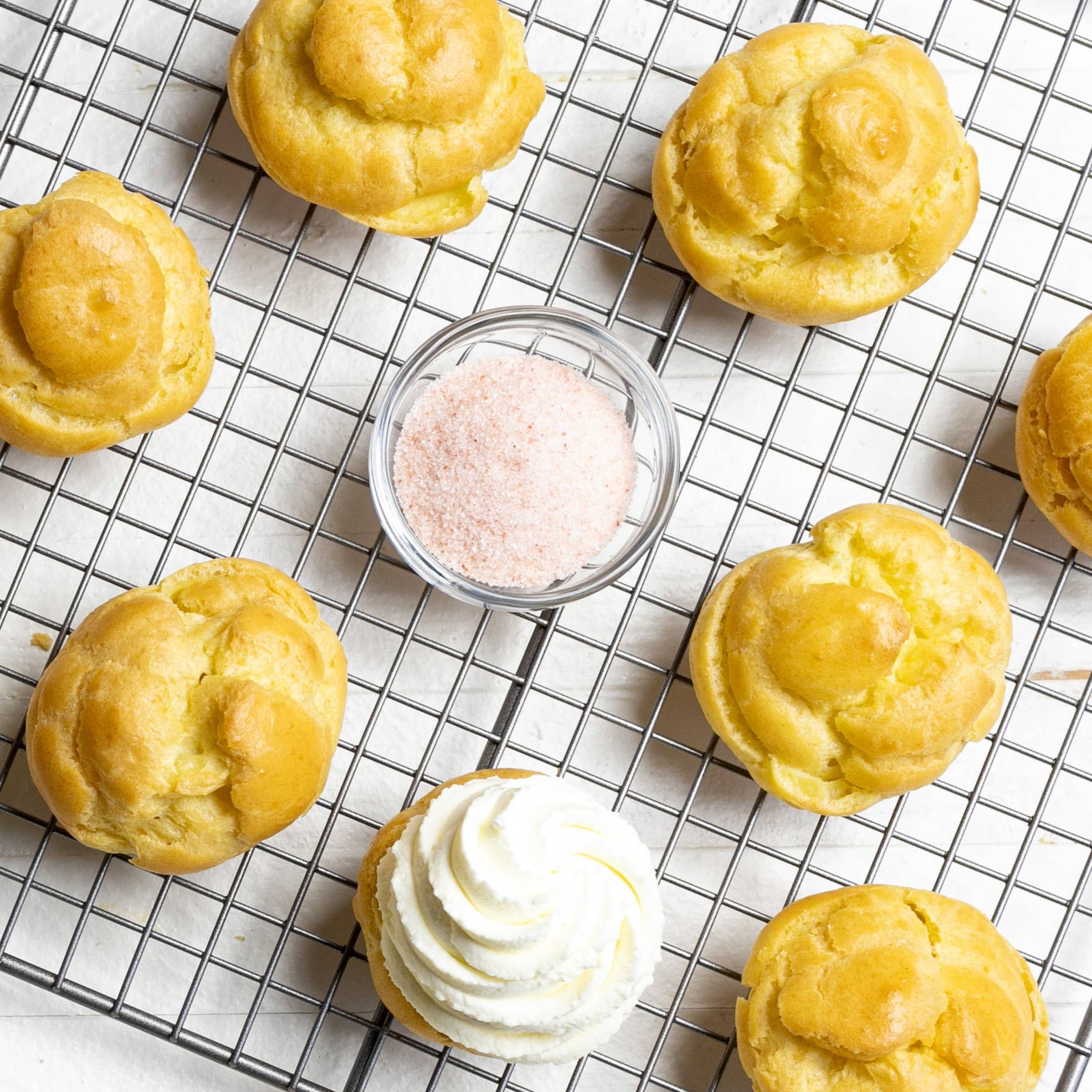 Pastries on a cooling rack with a small container of pink sea salt.