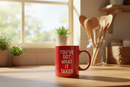 Red mug with white 'you've got what it takes' text on a wooden surface
