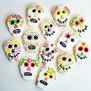 A collection of cookies in the shape of skulls and decorated to celebrate Dia de Los Muertos.
