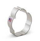 A stainless steel cookie cutter in the shape of a dog paw, with a visible made in America flag label.