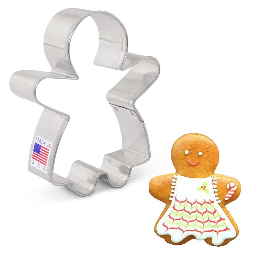 A gingerbread girl cookie cutter made of tin-plated steel, next to an illustration of a gingerbread cookie decorated with icing.