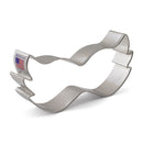 A stainless steel cookie cutter shaped like a Mardi Gras mask and a sticker on it stating it is made in the USA.