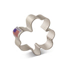A stainless steel mini shamrock cookie cutter with a 'Made in America' label on it.