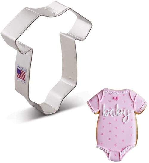 A cookie cutter shaped like a baby onesie with an example cookie with pink icing and 'baby' written on it