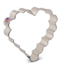 A metallic cookie cutter shaped like a scalloped heart with a 'made in USA' sticker.