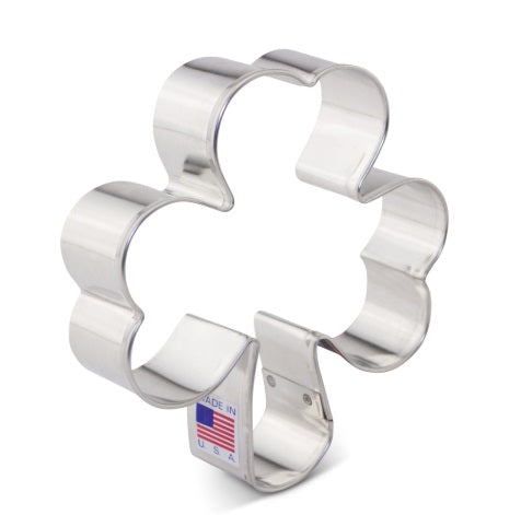 A stainless steel cookie cutter in the shape of a four leaf clover, commonly associated with St. Patrick's Day themes.