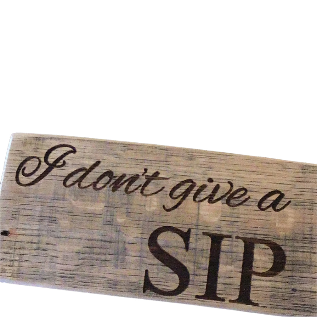 Wooden sign with 'I don't give a sip' text on a dark background