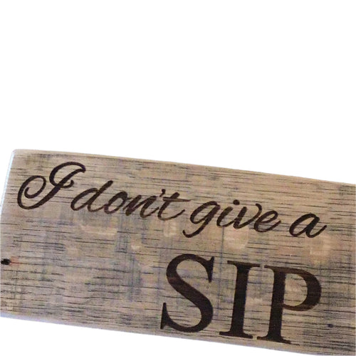 Wooden sign with 'I don't give a sip' text on a dark background