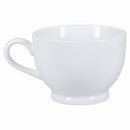 A white porcelain footed latte mug with a handle, isolated on a white background.