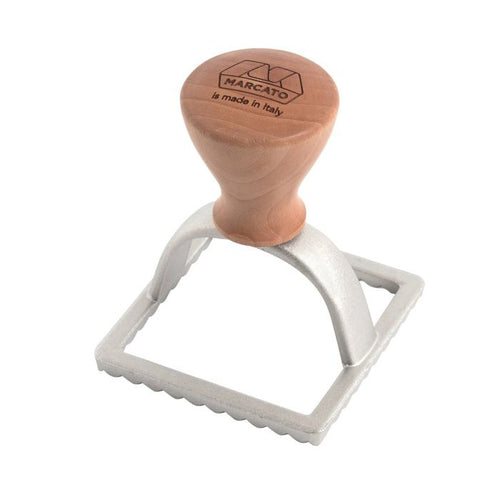 Marcato square-shaped ravioli stamp with a wooden handle and metal body, used for cutting and sealing pasta dough.
