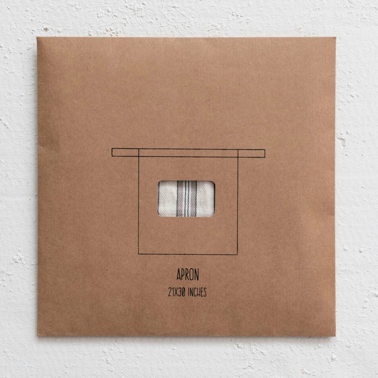 A brown paper package with a cotton half apron inside on a white background.
