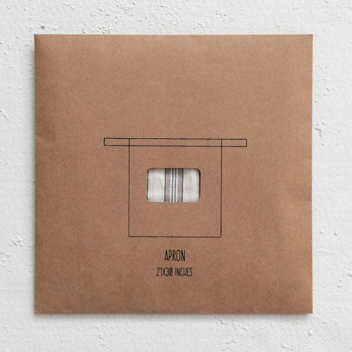 A brown paper package with a cotton half apron inside on a white background.