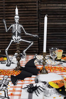 A Halloween-themed table setting with Hester & Cook table accents like skeletons, bats, and candy corn.