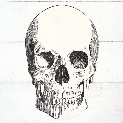 A die-cut paper placemat featuring a black and white skull design.