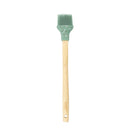Basting brush with wooden handle and green silicone head with holly design.