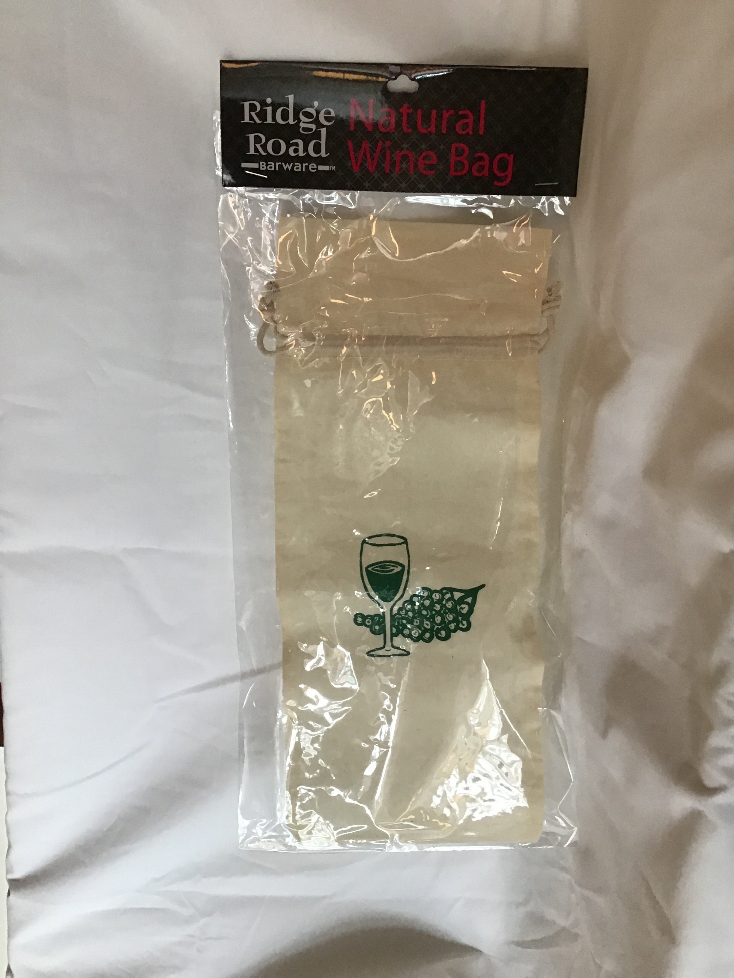A beige cotton wine bag with a green grapes logo, designed to hold wine bottles, sealed in a clear plastic wrapping with a label showing the brand and product information.