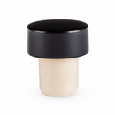 A solid black bottle stopper with a smooth finish, designed to fit standard bottles.