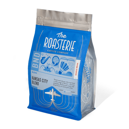 A pack of The Roasterie Kansas City Blend coffee, with branding and graphics that include a rocket, globe, and other Kansas City related imagery.
